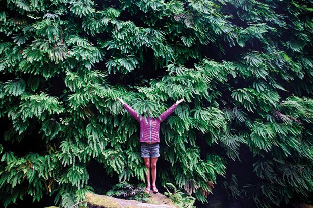 Woman hides her face in plant