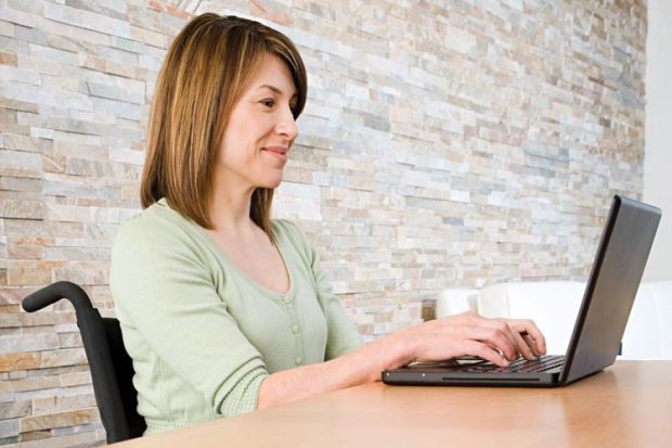 Woman in wheelchair using laptop