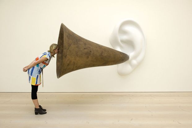 Woman looking into ear trumpet