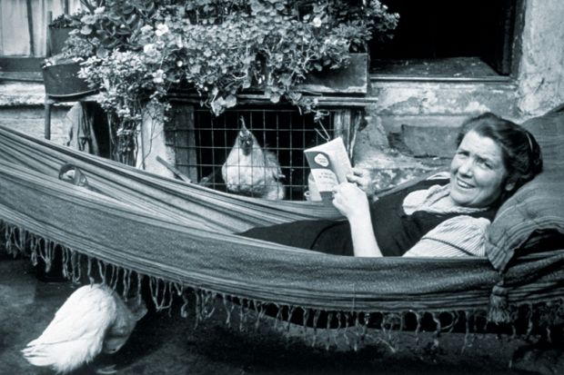 Woman lying in hammock reading book