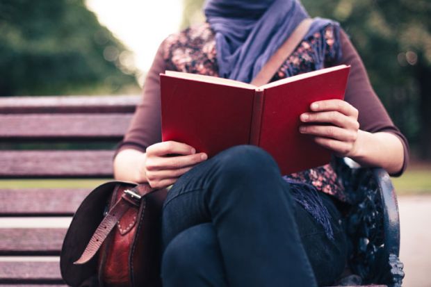 Woman reading on park bench