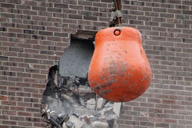 Wrecking ball demolishing wall