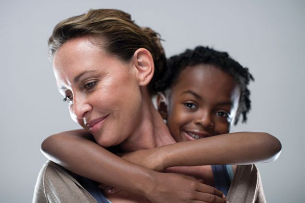 Young girl holding on to woman's back