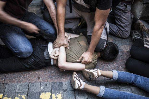 Young man pinned down on floor being arrested