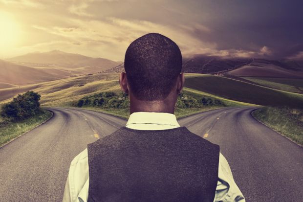 Young man standing at crossroads