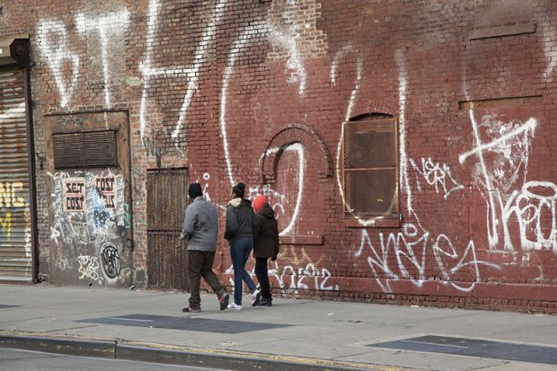 Young people walk in rundown neighbourhood