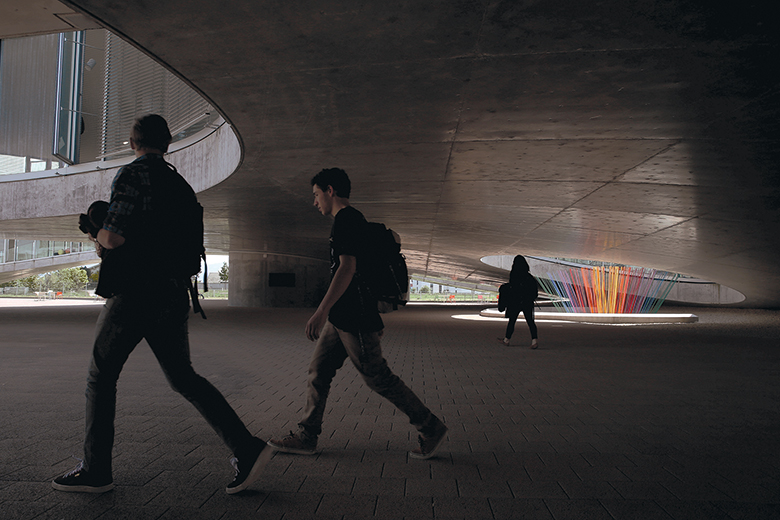 People walk under the Learning Center at the Ecole Polytechnique Federale de Lausann