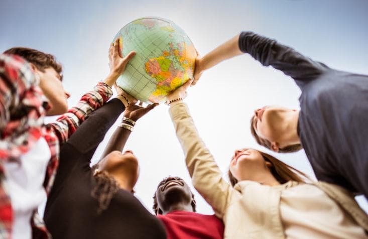 Students holding a globe